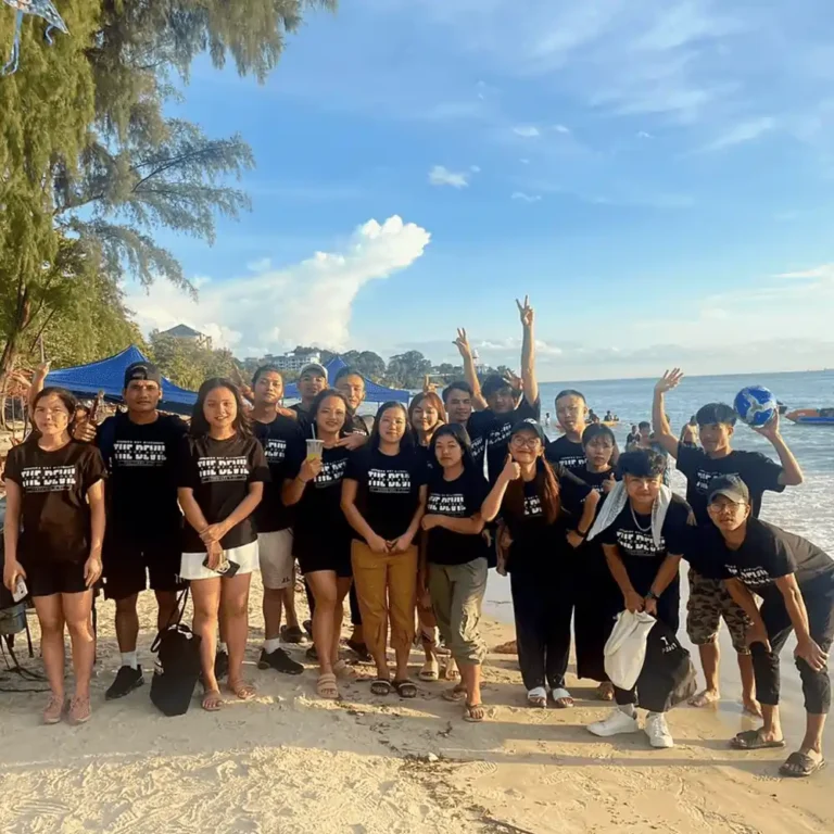 Church community event t-shirts Malaysia - Beach gathering participants wearing custom DTF heatpress printed black Arrive Guide premium 210gsm cotton shirts (AG210) for annual team building activity.